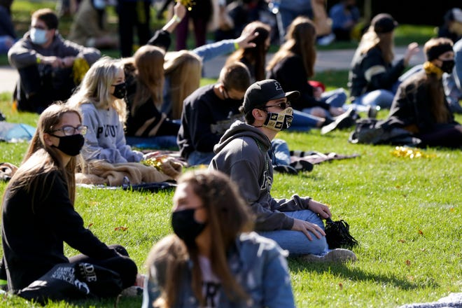 Students sit spaced out on the Purdue University Memorial Mall for a watch party for the Boilermakers football game against the Iowa Hawkeyes, Saturday, Oct. 24, 2020 in West Lafayette.
