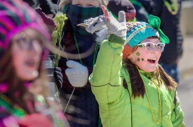 Corinne Christian, 9, of Dunlap tries to get some candy and beads from passing floats during the annual St. Patrick's Day Parade on Friday, March 17, 2023 in downtown Peoria.